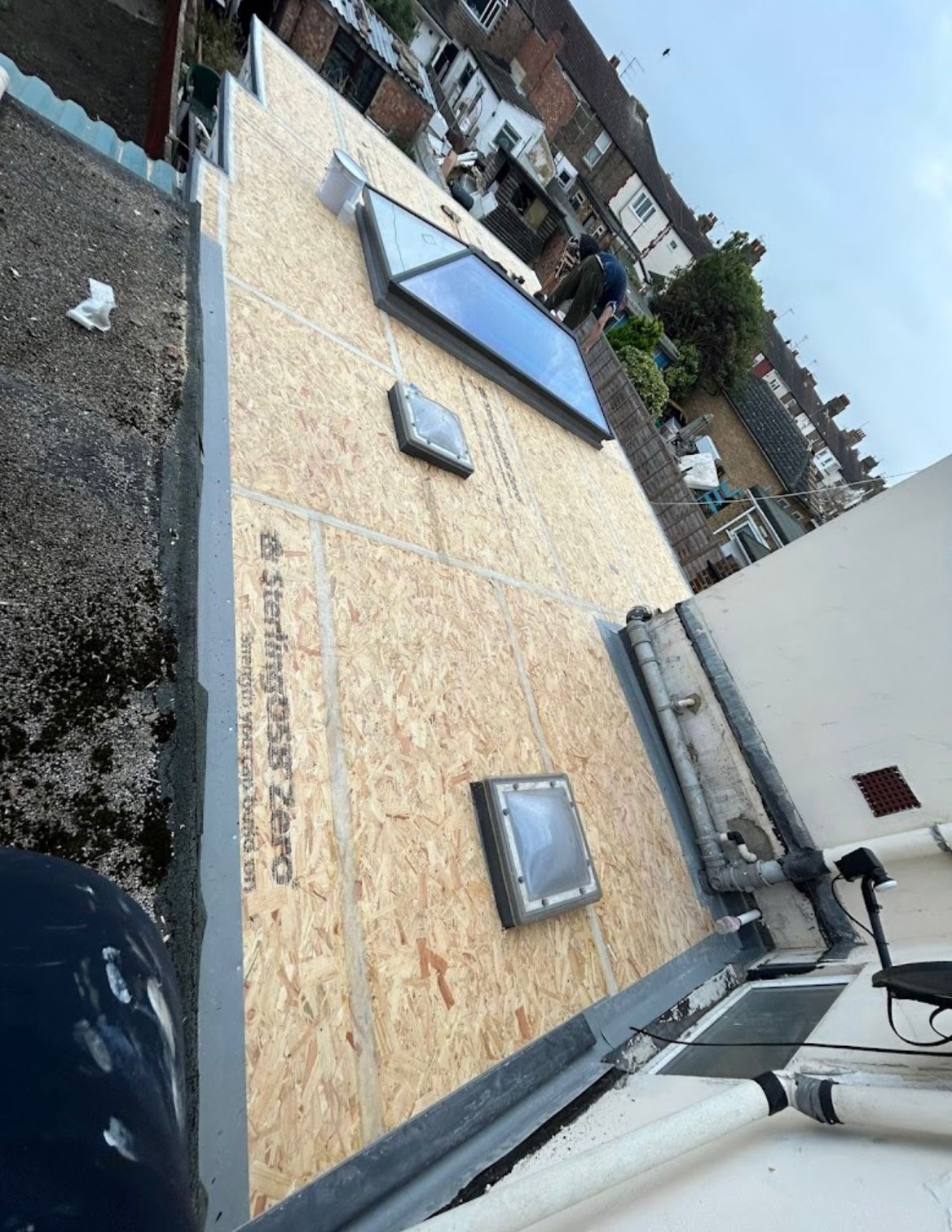 New OSB flat roof deck with skylight and roof lanterns being installed during a flat roof replacement in Essex